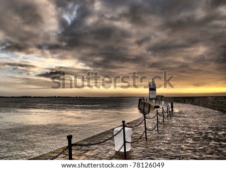 Dramatic HDR Set. Cloudy Sky and Stony Path to the Lighthouse with Sunrise over the sea
