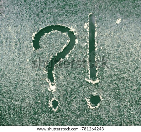 Question and exclamation marks written on frosted window. Abstract symbols.
	
