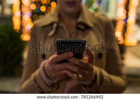 Closeup of female hands typing an sms message via smartphone outside,woman enjoying evening walk and using his cellphone, hands using app with city touristic map via modern smartphone device outdoors