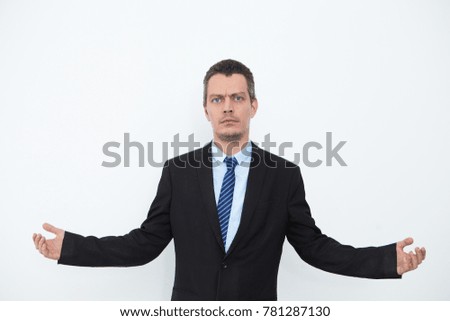 Serious young businessman outstretching arms