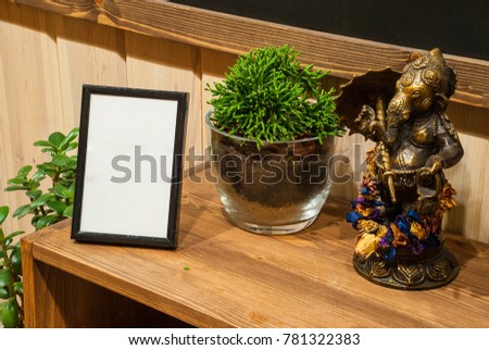 statue Ganesha in interior with photo frame. Son of Shiva and Parvati. God eliminating obstacles in India