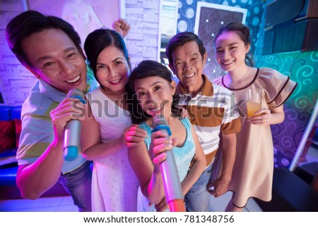Group of happy Vietnamese people spending time in karaoke