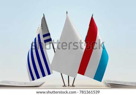 Flags of Uruguay and Luxembourg with a white flag in the middle