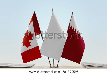 Flags of Canada and Qatar with a white flag in the middle