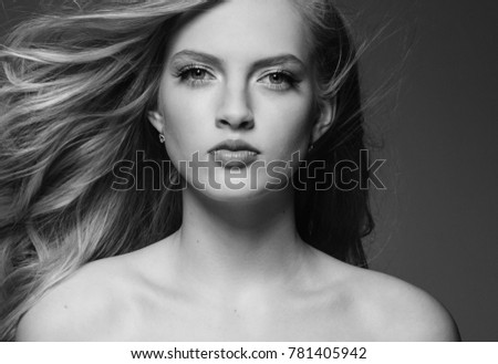 Beautiful woman with blonde long hair over gray background black and white