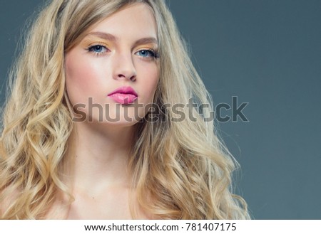 Beautiful young blonde hair girl with pink lipstick and long blonde hairstyle curly and healthy