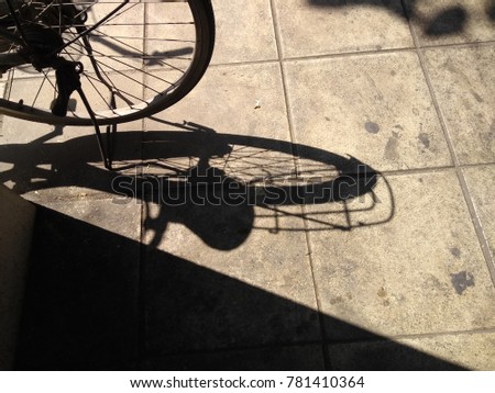 Shadow bike on the sidewalk by the road in the daytime.