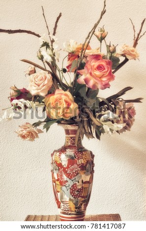 Still life of silk flowers in a Japanese satsuma vase.