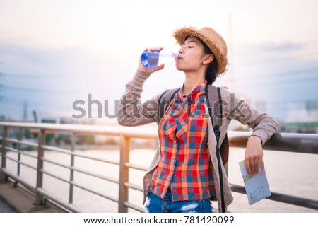 Asian girl Drinking water Stay tired of thirst tourist backpack relax time on holiday.