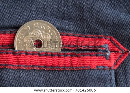 Denmark coin denomination is two krone (crown) in the pocket of worn blue denim jeans with red stripe