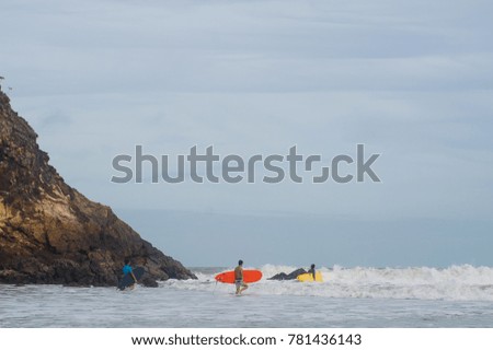 surfers cross beach