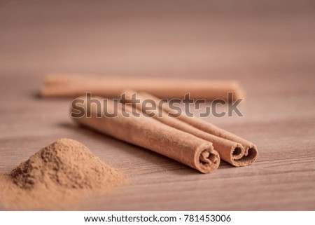 cinnamon sticks and powder on wooden table. 