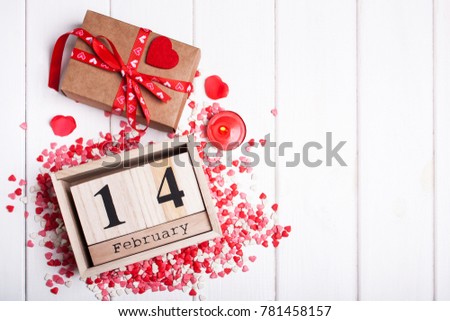 February 14 calendar for Valentine's Day and a gift on a white background. View from above