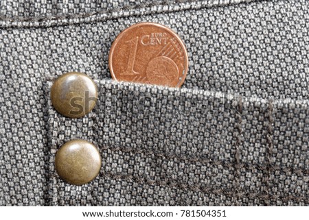 Euro coin with a denomination of 1 euro cent in the pocket of old worn brown denim jeans