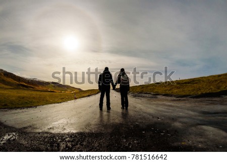 Couple walking on a frozen road on a winter night in Iceland. with full moon.