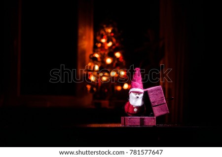 Red Christmas gift box and fir tree on snow. Christmas home decoration with snow and tree on a dark background with copy space. Selective focus. New Year attributes on background
