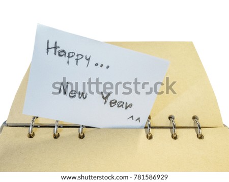 White note written on Happy New Year's Day is placed on a brown book , Craft paper