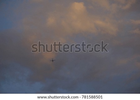 Airplane flying high on sunset sky