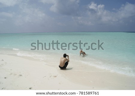 Tourists taking photos in an amazing beach of Maldives islands