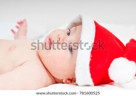 Charming newborn baby dressed as Santa Claus on the bed