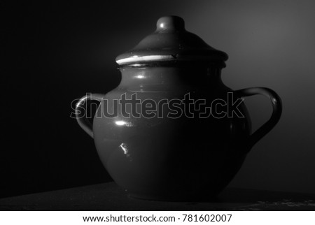 Black and white photograph of metal sugar bowl with dark background