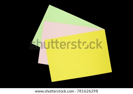green, pink and yellow paper isolated on black background