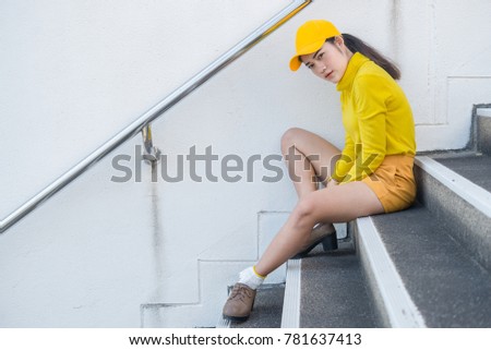 Portrait of beautiful asian woman in yellow cloths,Hipsters girl wear yellow hat sit on stair for take a picture,Thailand people