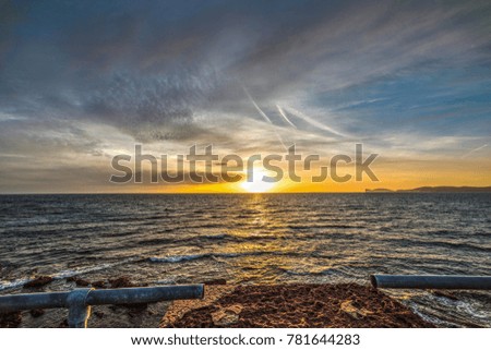 Alghero shore under a cloudy sky at sunset, Sardinia