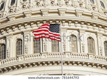 Capitol Building dome detail with waving American flag - close up view, Washington DC, United States of America