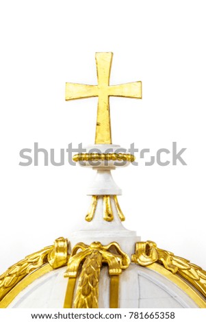 Close-up photo of a golden cross symbol against white background.