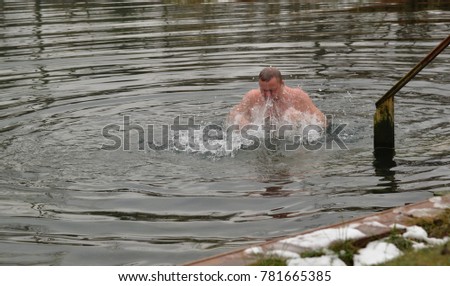 Man  is swimming  in lake in winter
