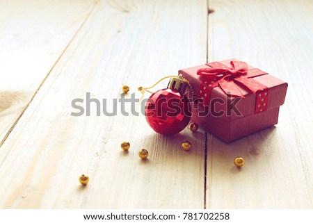  Red gift box and red ball on wood plate                               