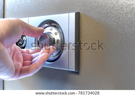 Closeup image of a hand opens a mechanical lock of a safe. High resolution studio image. Item is safe and combination. Royalty-Free Stock Photo #781734028