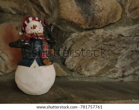 Snowman sitting on fireplace mantle ready for winter