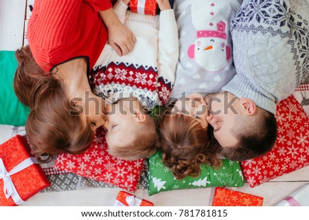 Happy big family on a festive day lies at the box office gifts. Gifts for children. Parents love their son and daughter very much. ma and dad kiss their children. Cheerful funny family
