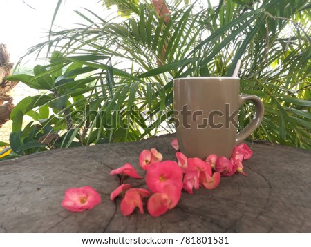 Cup of coffee, red flower, pink on old tree stump, palm leaf, 
Happy New Year 2018