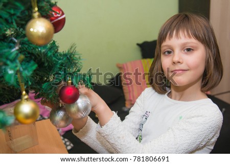 The girl decorates the New Year's tree
