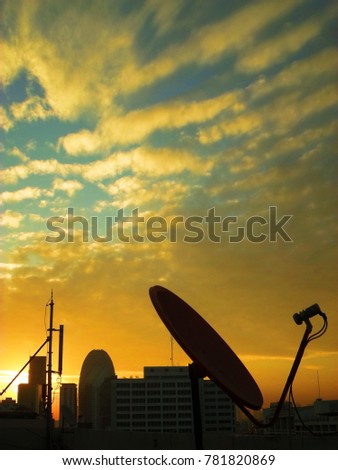 satellite receiver and other telecommunications on top floor building before sunrise morning time with dark blue and orange sky background.  it can be used and applied for media presentation.
