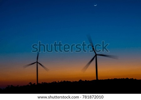 Silhouette of wind power station on sunset. ( use Low Shutter Speed To show movement of propeller)