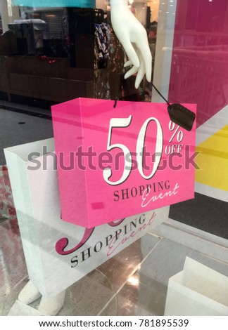 Boutique mannequin holding a shopping bag with /sale sign avertisement