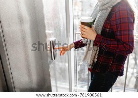 The thumb presses the Elevator button, a hand reaching for the button, the girl waiting for Elevator, push button start, isolated, the girl with the jar of coffee