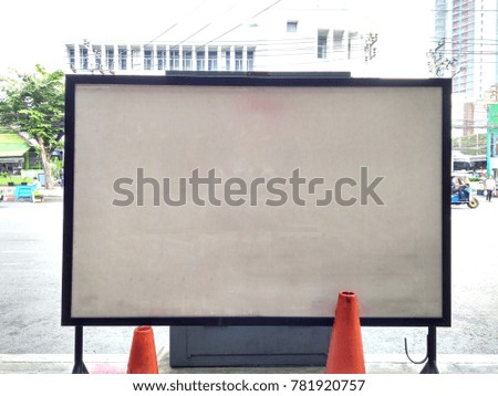 A large white board is located beside the road.