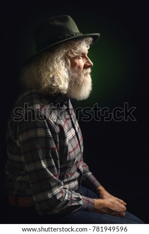Senior man in hat on dark background