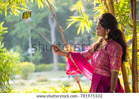  Happy asian woman taking selfie with selfie stick.