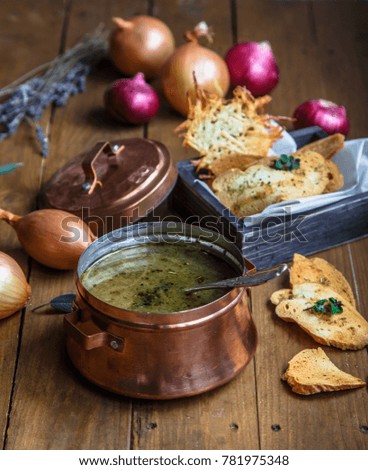 Close view of copper pot with onion soup and croutons