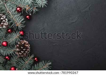 Evergreen tree handmade toys, snowflakes, red globes and fir branch on black stone background, view from top, above, Xmas greeting card with space for text wish Royalty-Free Stock Photo #781990267
