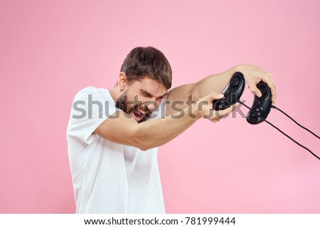 man with joysticks playing in playstation on a pink background                               