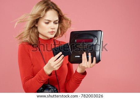 woman with playstation and joystick on a pink background, game console                               