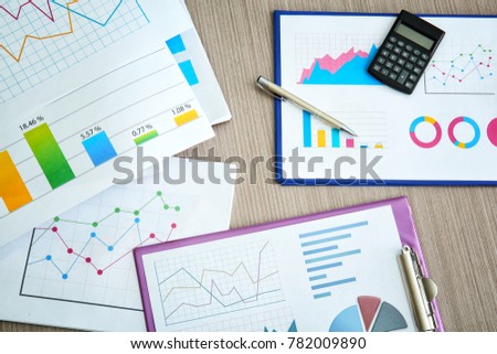 Documents with graphs and charts on table