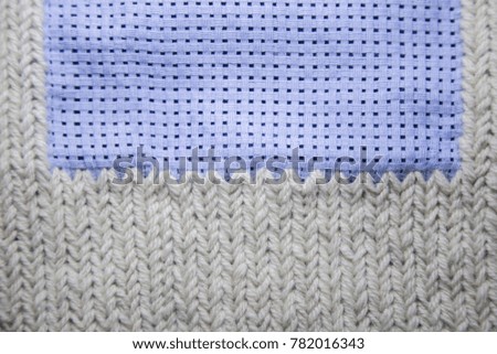 A beautiful pattern of hand made needle point stitch in gray and blue tones